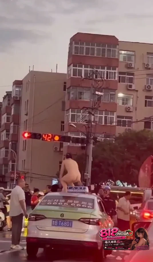 青岛街头惊现裸女车顶热舞!女子当街脱光衣服扭腰摆臀,出租车顶成舞台,路口车辆行人全看傻,场面混乱又荒诞!